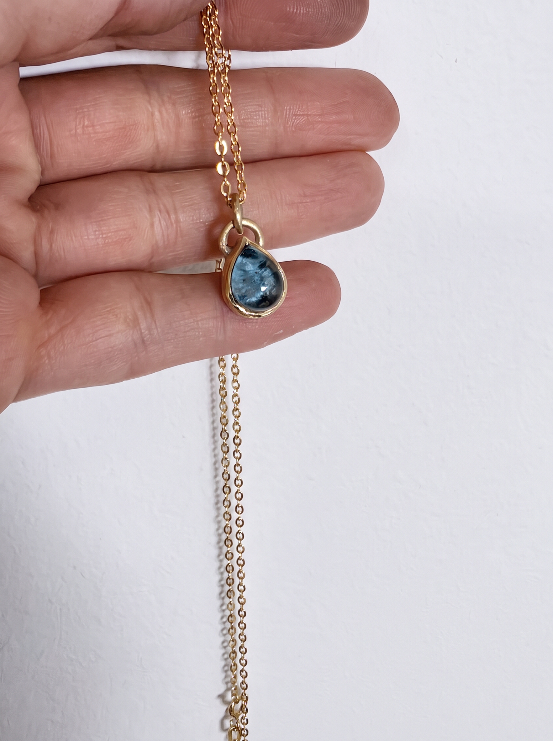 Colgante Alma Gota de oro 14k con cenizas 3 Colgante Alma Gota de oro 14k con cenizas sostenido en la mano