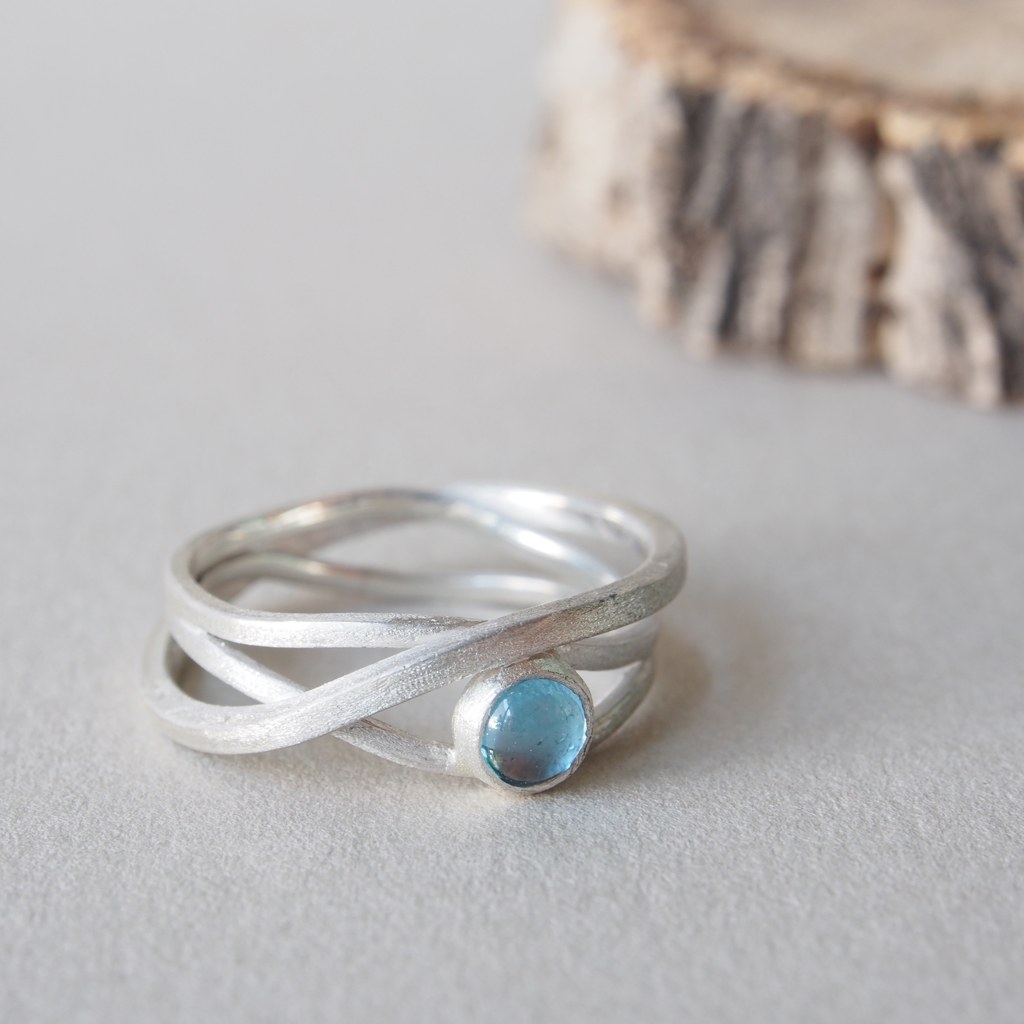 Anillo Etapas de plata con topacio azul visto de lado