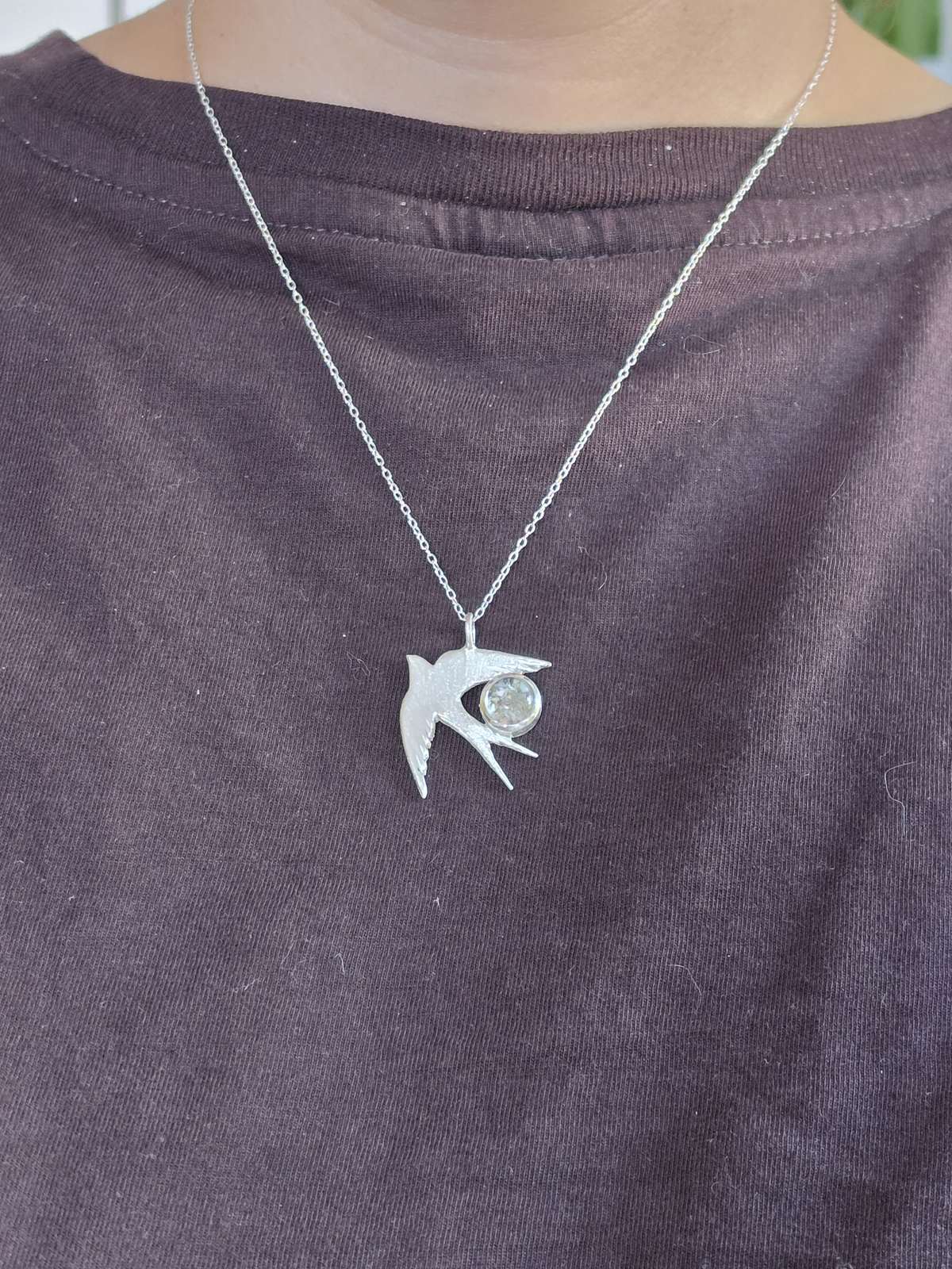 Colgante Golondrina de plata con cenizas puesto