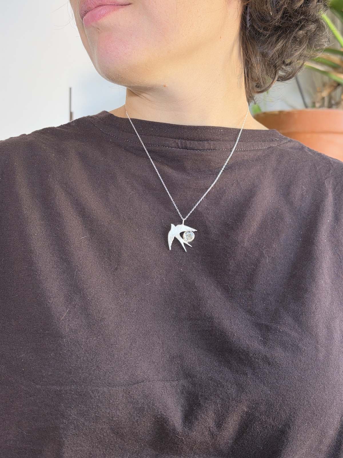 Colgante Golondrina de plata puesto, de perfil